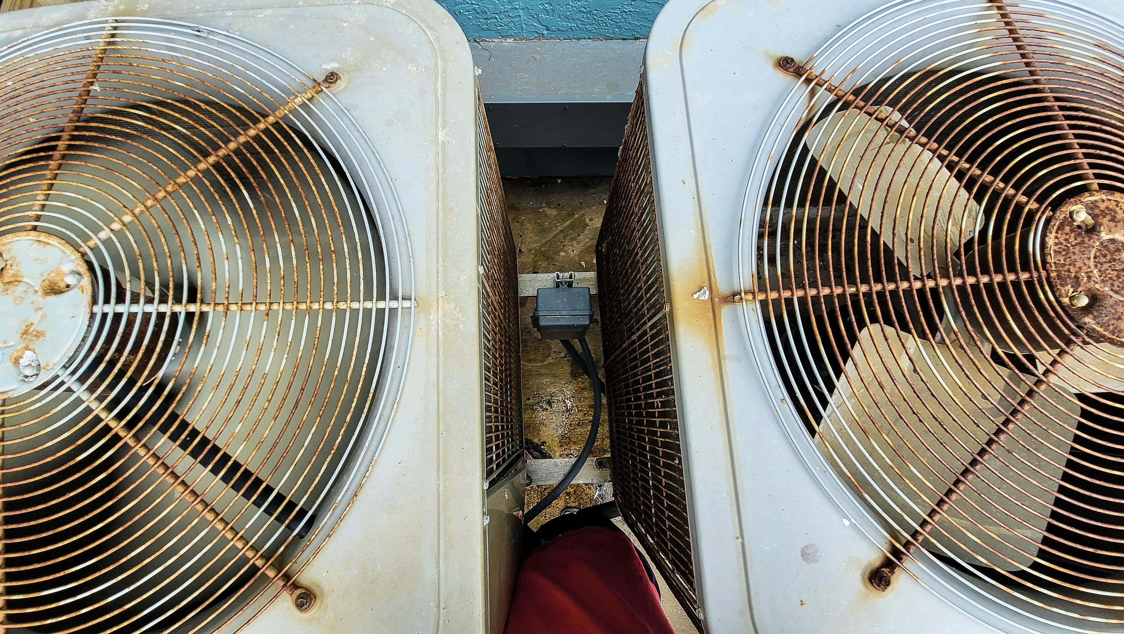 Rusted and weathered HVAC appliances showing severe deterioration and rust damage